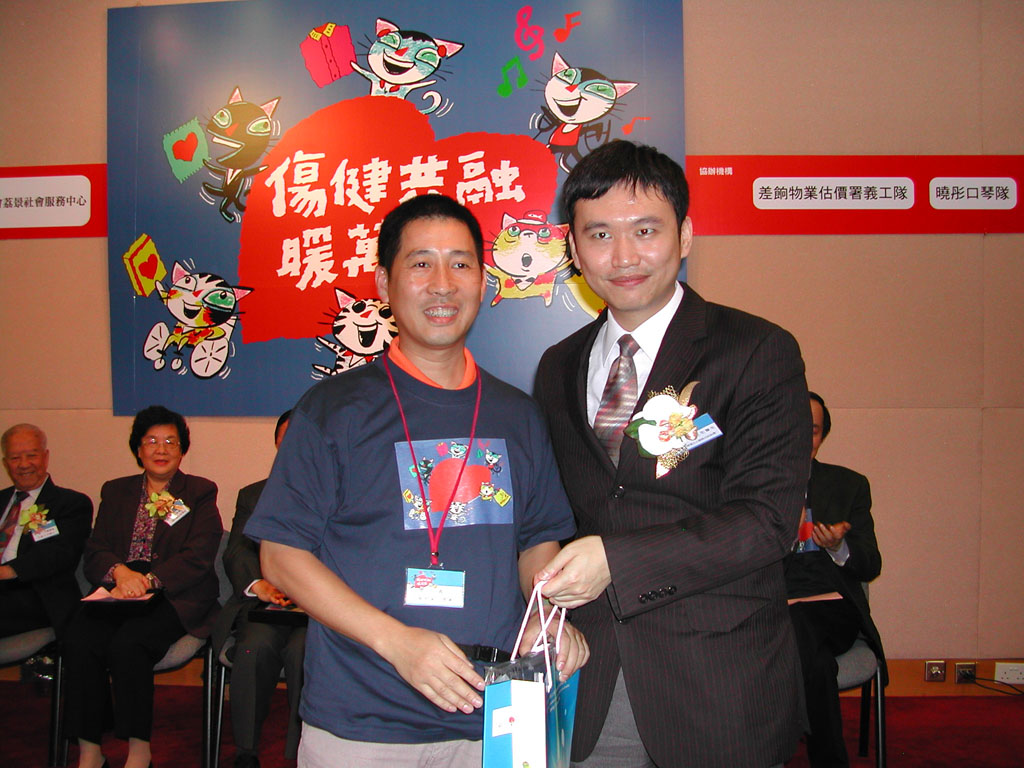 黃至生醫生頒紀念品予義工隊代表。