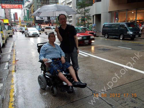 義工顧家俊先生為會員撐傘遮雨